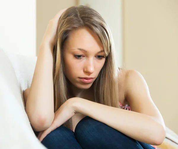 Ragazza con i capelli lunghi seduta sul divano — Foto Stock