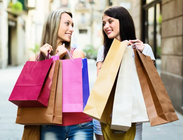 Twee lachende meisjes met shopping tassen — Stockfoto