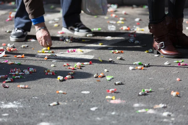Människor samlar karameller från asfalt — Stockfoto