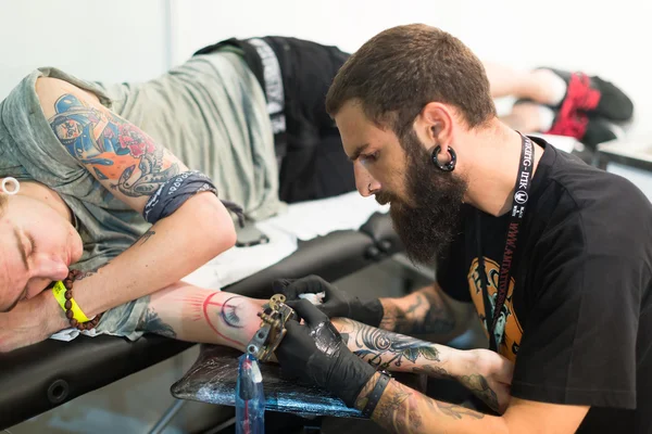 Artist doing  tattoo on client — Stock Photo, Image