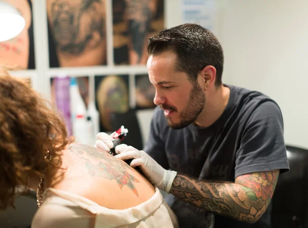 Master gör färgglada tatuering — Stockfoto