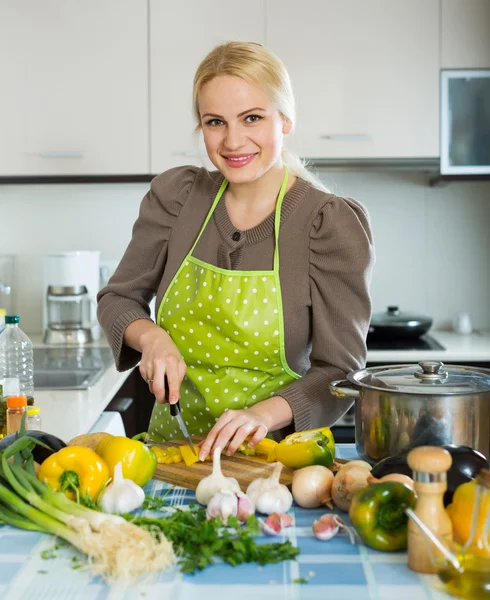 Smiling woman slicing pepper — Stock Photo, Image