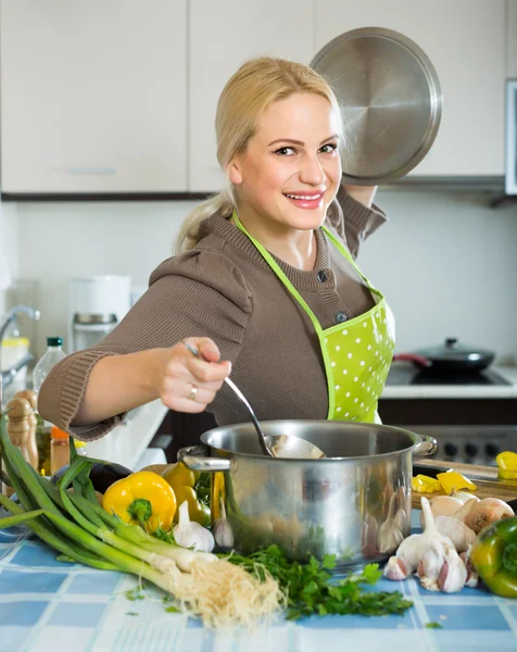 Kvinna i förklädet på hem kök — Stockfoto