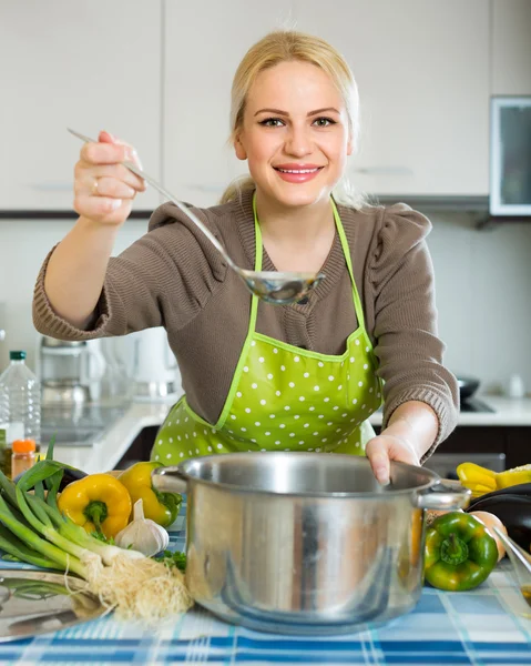 Žena v zástěře v domácí kuchyni — Stock fotografie