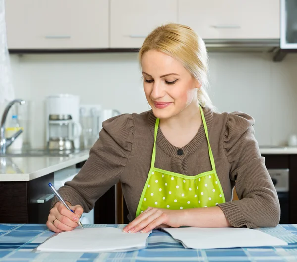 Frau mit Dokumenten in der Küche — Stockfoto