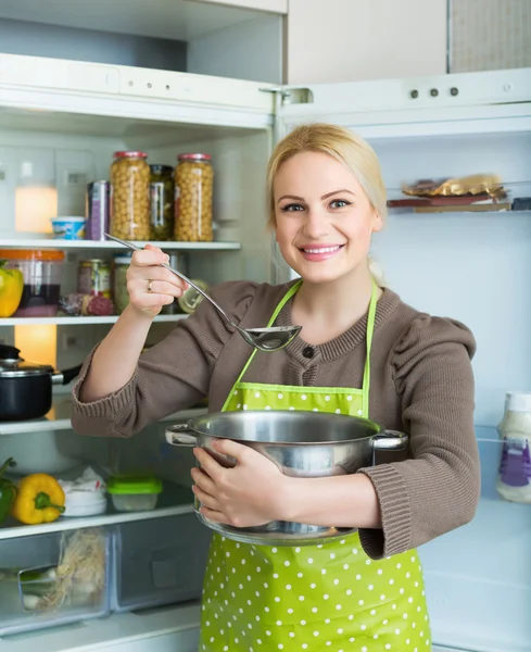 Женщина ест суп из сковороды — стоковое фото