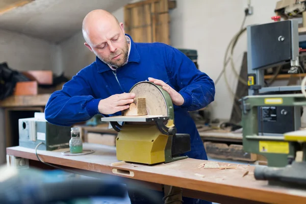 Man working on a machine at guitar workshop — Stock Photo, Image