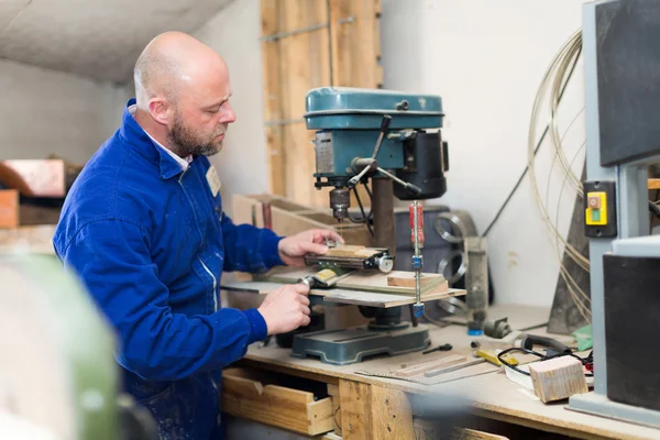 Man working on a machine at guitar workshop — Stock Photo, Image