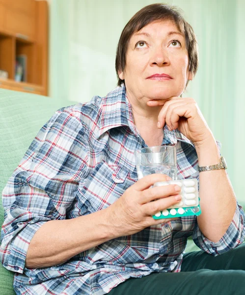 Femme avec des pilules et un verre d'eau — Photo