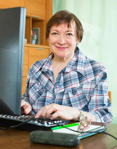 Sênior feminino usando teclado — Fotografia de Stock