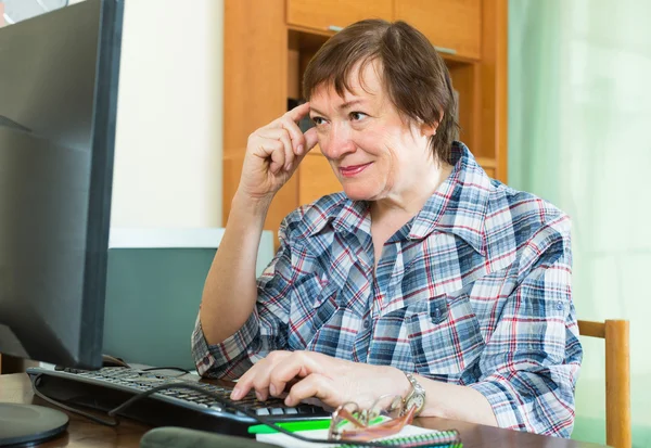 Sênior feminino usando teclado — Fotografia de Stock