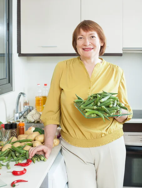 Mature woman with okra — Stock Photo, Image