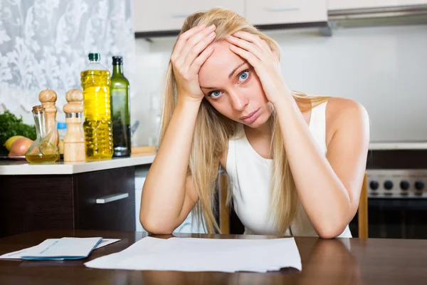 Traurige Frau mit Finanzdokumenten — Stockfoto