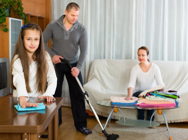 Meisje met ouders thuis schoonmaken — Stockfoto