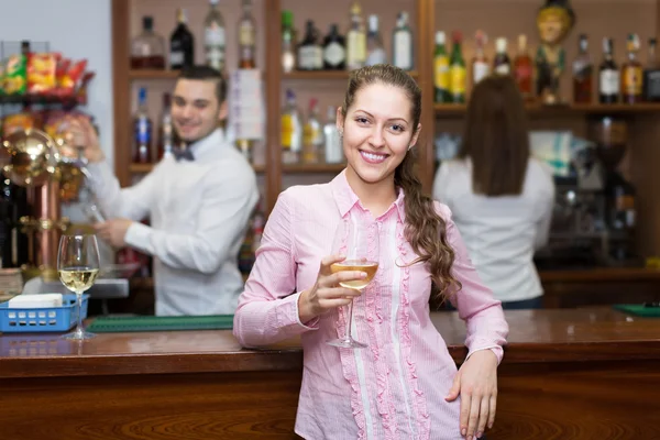 Ragazza in piedi al bar con bicchiere di vittoria — Foto Stock