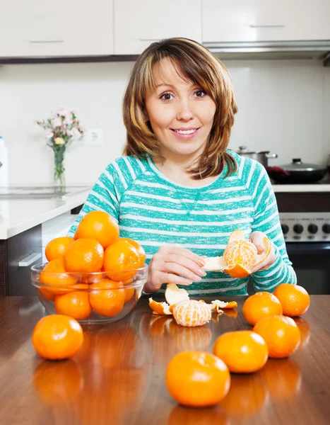 Mulher sorridente com tangerinas — Fotografia de Stock