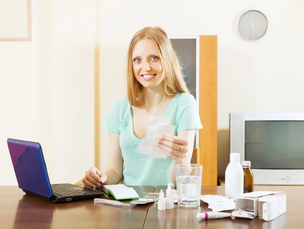 Kvinna läser om mediciner i laptop — Stockfoto