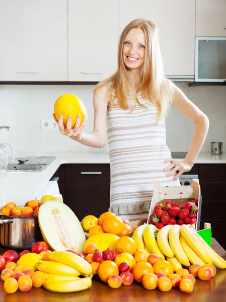 Mujer con melón y montón de frutas — Foto de Stock