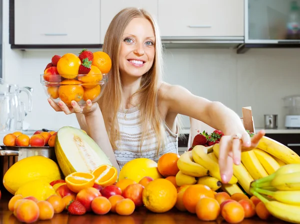 Glückliche blonde Frau, die Früchte auswählt — Stockfoto