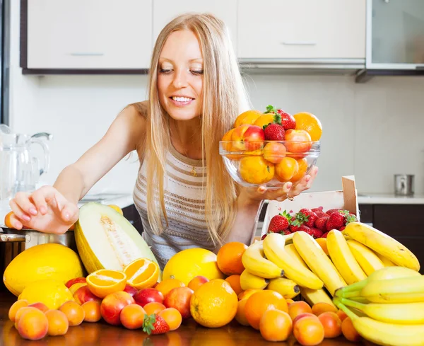 Kvinna med frukter från tabell — Stockfoto