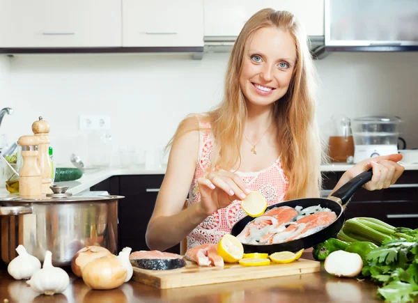 Chica cocinar salmón con limón — Foto de Stock