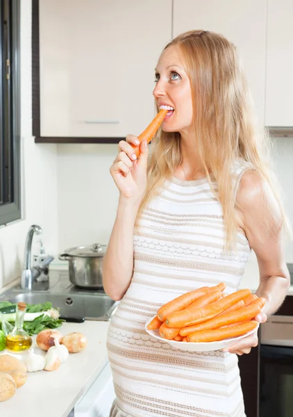 Gravid kvinna äta morötter — Stockfoto