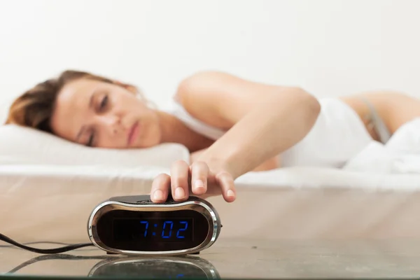 Woman  switching off the alarm clock — Stock Photo, Image