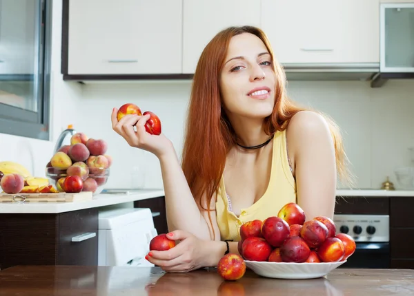 Woman with nectarines in kitchen — Stock Photo, Image