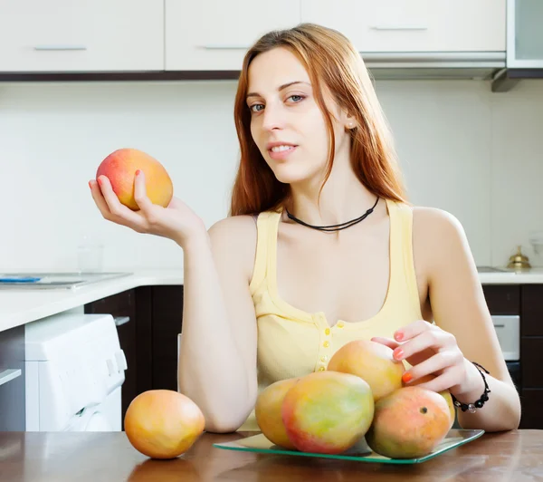 Kvinna anläggning mango — Stockfoto