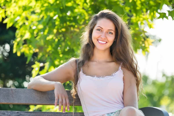 Jonge vrouw zittend op bank — Stockfoto