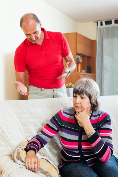 Traurige reife Frau hört wütendem Mann zu — Stockfoto