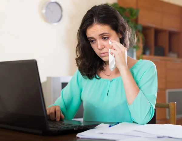 Sad woman with documents and laptop — Stock Photo, Image