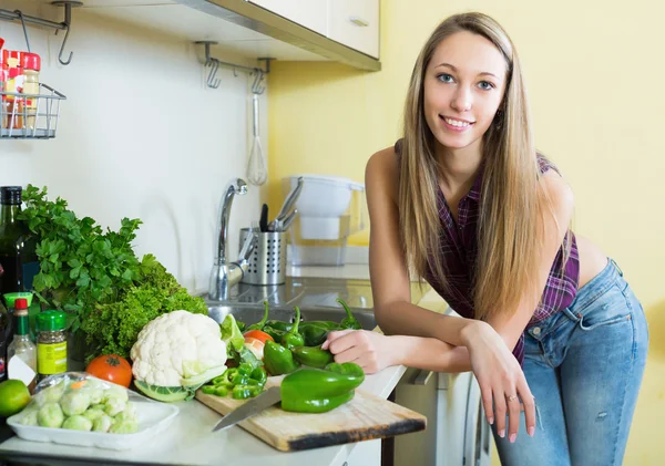 Leende flicka skivning grön paprika — Stockfoto