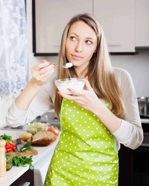 Donna in grembiule mangiare formaggio cagliata — Foto Stock