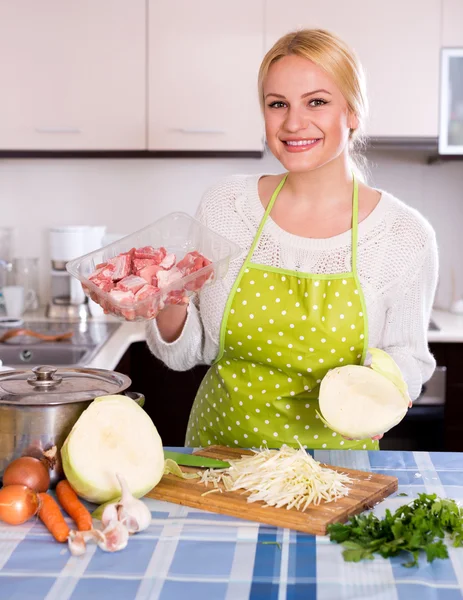 Blonde in apron with meat — Stock Photo, Image