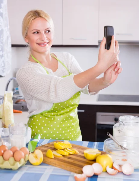 Девушка со смартфоном на кухне — стоковое фото