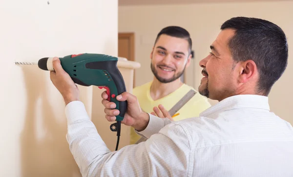 Two men with drill and level — Stock Photo, Image