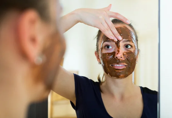Woman applying mask on her face — Stock Photo, Image