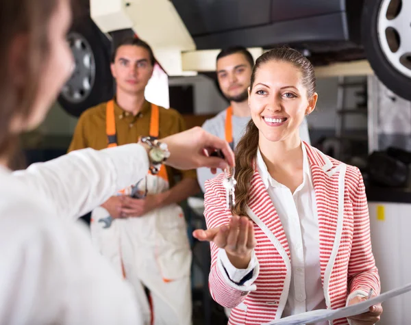 Owner giving car's keys to assistant — Stock Photo, Image