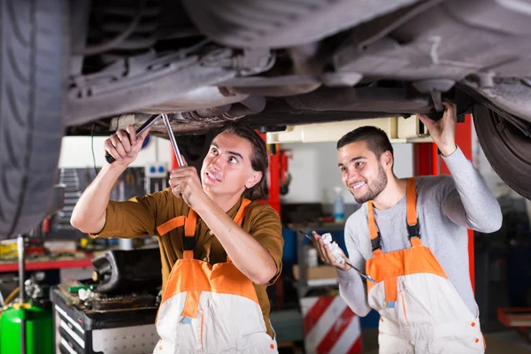 Serviceman repairing car of client — Stock Photo, Image