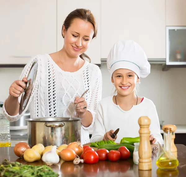 Sonriente chica y mamá en la cocina —  Fotos de Stock