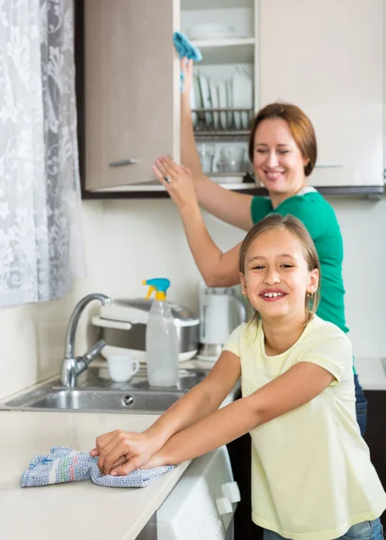 Girl and mom tidy kitchen up — Stock Photo, Image