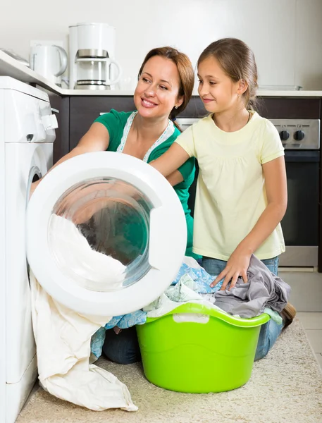 Kızı çamaşır makinesi yakınındaki kadınla — Stok fotoğraf