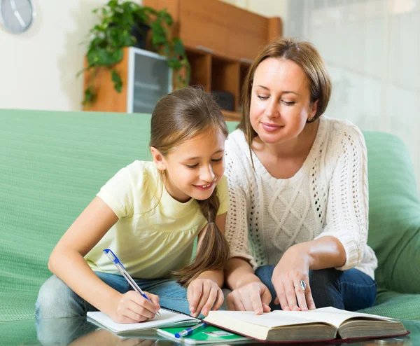 Schoolgirl and mother doing homework — Stock Photo, Image