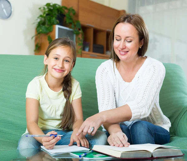 Schoolgirl and mother doing homework — Stock Photo, Image