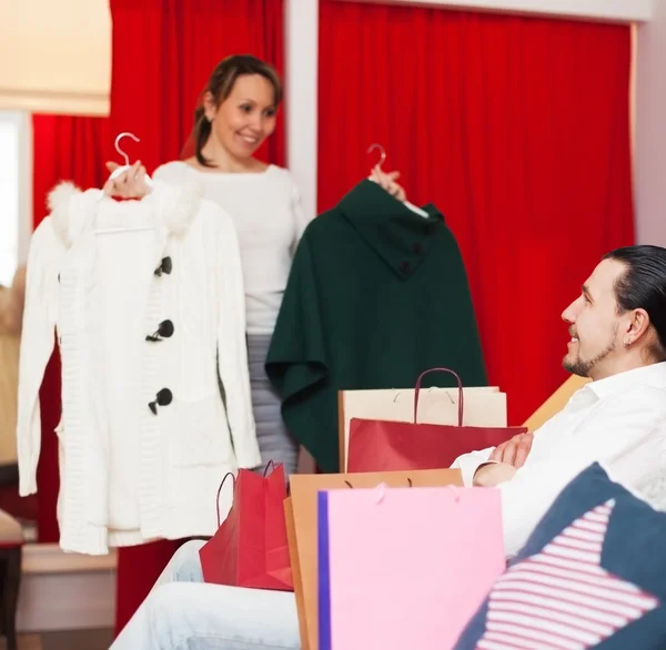 Couple choosing coat at boutique — Stock Photo, Image