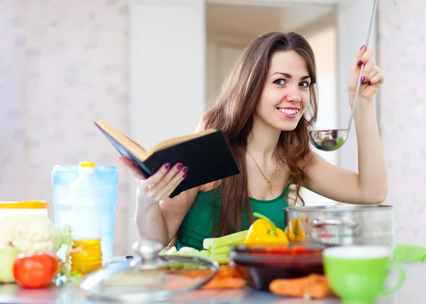 Mulher cozinhar com concha e livro de receitas — Fotografia de Stock