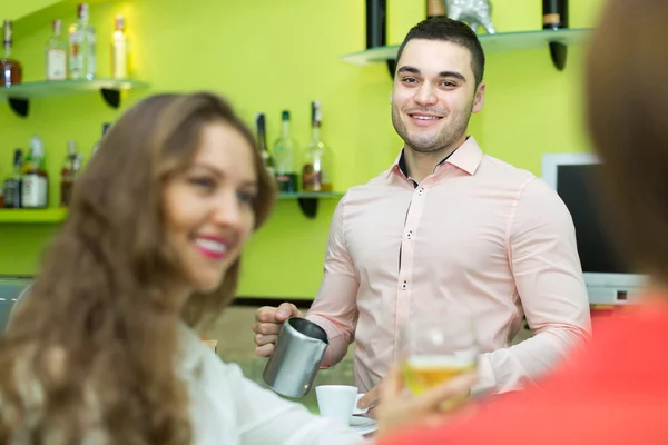 Bartender and smiling women at bar — Stock Photo, Image