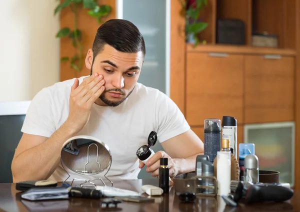 Homme appliquant de la crème sur la peau du visage — Photo