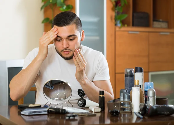 Mann trägt Gesichtscreme auf — Stockfoto